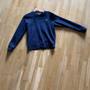 Lacoste mörkblå-marinblå (tröja/sweatshirt) - Nästan helt oanvänd Lacoste sweatshirt, ser ut som ny!   83% bomull   I stl XS, passar även S 