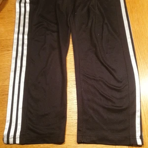 Adidas mjukisbyxor strl 160 - Syntetmaterial. Något slitna. Raka ben utan mudd, fickor med dragkedja. Innerbenlängd 62 cm