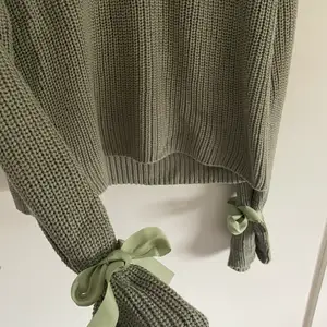 Grön stickad tröja med rosett vid ärmarna. Går att justera banden så man knyter de som man själv vill. Köpt från bubbelroom. Använd 1-2 ggr. Säljer pga att den inte kommer till användning. 