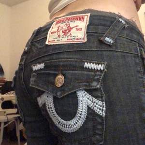 Lågmidjade True Religion jeans med broderier på fickorna! Midjemått: 76 cm Innerbenslängd: 80 cm. Finns en liten fläck på baksidan som jag inte lyckats få bort, men det är inget man lägger mycket märke till. Säljer då de inte kommer till användning.💋💋