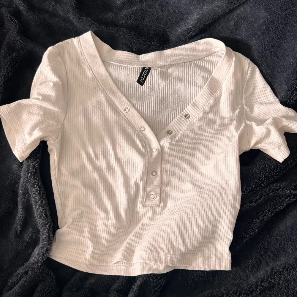 En vit tröja från H&M som är i bra skick. Knapparna på tröjan kan man ha hur man vill. Säljer pga den inte kommer till användning.🤍  (Obs står ej för frakt eller postens slarv). Toppar.