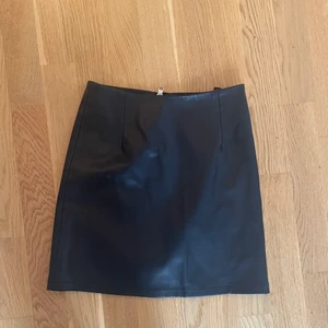 Läderkjol Bikbok  - Svart läderkjol från Bikbok  Ej äkta läder   Stretchigt material  Strl xs  Endast använd en gång   Längd 41 cm 