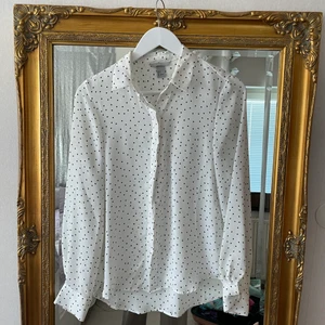 Prickig blus - Svart och vit prickig blus i klassisk stil. Kan bäras avslappnat men också till finare tillställningar. Storlek S/XS. 