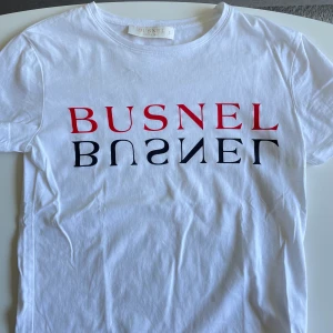 Busnel - Vit T-shirt med tryck från Busnel i storlek 34. Tröjan är i mycket fint skick & nästintill oanvänd. Pris 250 kr eller högstbjudande.