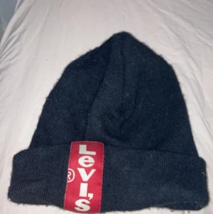 Lewis mössa.  - Levis mössa.  Passar mig som är 15, men har haft den sen jag va i 12-13, så passar garanterat i den åldern också. Givetvis äkta!  Använt skick, men i bra skick. 