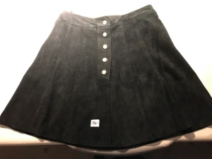 Mocka kjol  - Snygg välbehållen mocka kjol i svart med knappar framtill. Mycket obetydligt använd. Oklart vilken storlek men uppskattas som S 