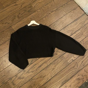 Croppad svart stickad tröja - En jättefin tröja från H&M ! Säljer då den inte kommer till användning längre  Köparen står för frakt
