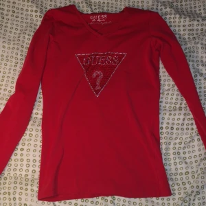 Guess long-sleeved tröja - Rosa röd långärmad tröja med rhinestone tryck på framsidan, använd mycket sällan så den är i bra skick.. Köpt i USA för några år sedan