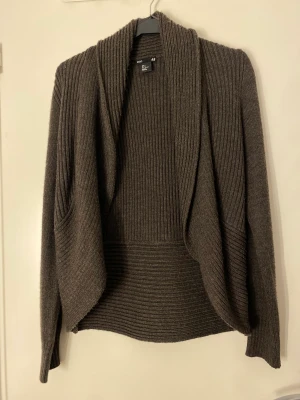 Stickad kofta - En brun/grå stickad kofta från H&M i storlek S.