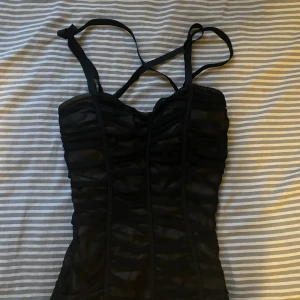 Body - Body köpt second hand. Banden bildar ett kryss i back, fråga om ni vill ha fler bilder. Har en väldigt fin passform.