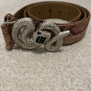 Bälte - Säljer ett coolt välte med  ormskinn och en orm på som detalj!