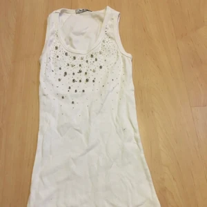 Oanvänt linne i ca storlek S/M - Oanvänt ribbat linne. Enligt storlekslapp storlek M/L men uppskattar att det är mindre cirka storlek S/M. 