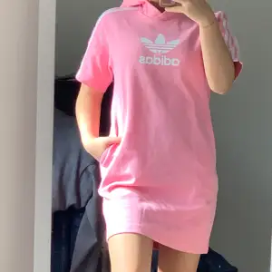 En Adidas klänning med en luva i en rosa färg 