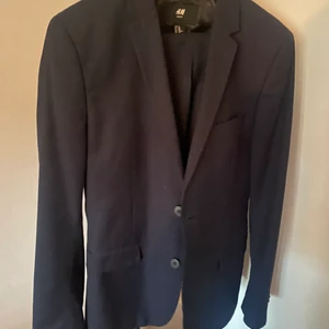 Kostym HM - Mörkblå kostym fr H M. Vit herr skjorta stl S slim  fr HM medföljer.lagt upp byxan. Tottal längd 97 vm. 