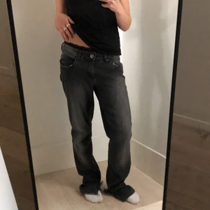 Gråa lågmidjade jeans - Gråa lågmidjade jeans med slits längst ned. Aldrig använd, alltså i nyskick. Frakt tillkommer på 66kr, kontakta mig gärna vid frågor💕