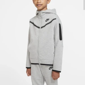 grå nike tech - säljer min nike tech, både byxor och tröja. tröjan är strl L och byxorna XL (barnstorlek). båda passar mig som är 165 (tröjan ytterst lite kort i armarna) jättefint skick byxorna endast använda 2 ggr tröjan ca 6 ggr. 