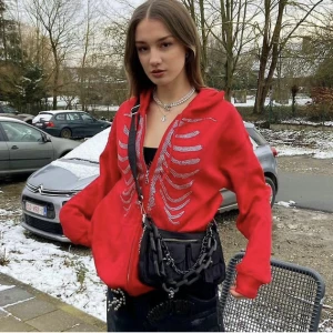 Röd skellet hoodie - Röd skellethoddie med rhinestones köpt här på plick! Första bilden är lånad, storlek L men jag är XS. Möts i Uppsala eller så står köpare för frakt!:)