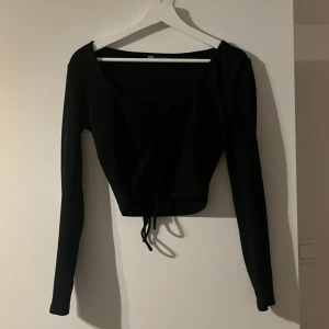 Svart långärmad ribbad - Ribbad långärmad tröja från zara med dragsko i mitten, storlek L men skullle säga att den passar både M och S
