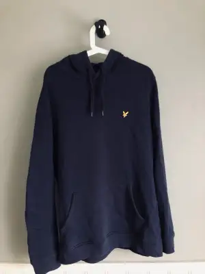 En mörkblå Hoodie av märket lyle & scott. Storlek large och i bra skick.