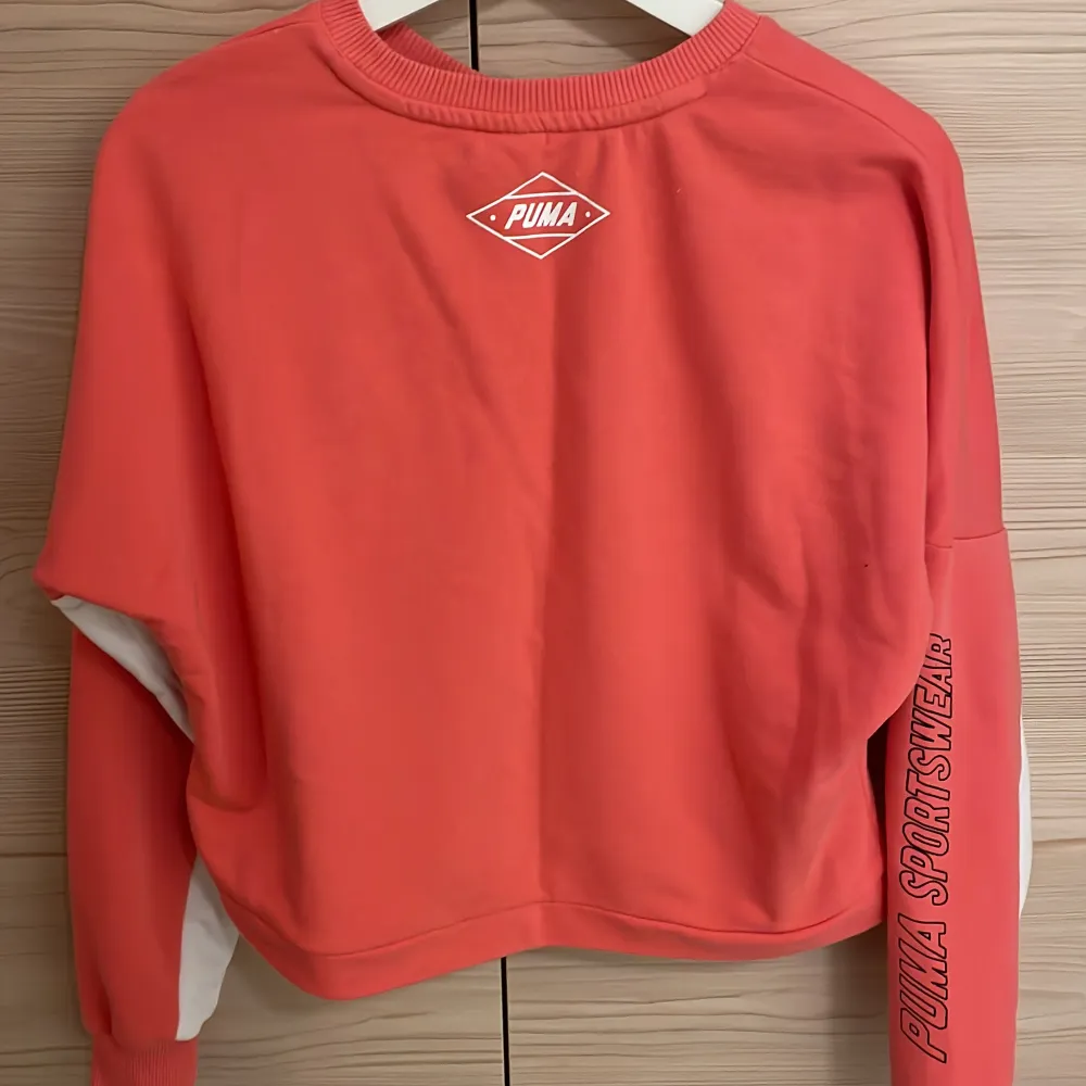 Rosa sweatshirt från Puma. Storlek XS. Tryck på ena ärmen.. Hupparit & Collegepaidat.