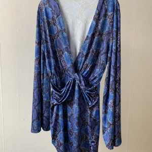 Blå snake skin klänning - Storlek L. Kort, tight fit cocktailklänning med utavänga ärmar. Aldrig använd!