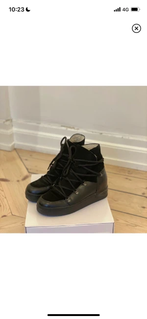 Mocka/Skinnboots (37) JACKIE - Boots tillverkade av äkta läder och skinn med lammull på insidan (skitvarma). Sulan ger en lite höjd på 4 cm. NYPRIS: 1900 kr. Köptes på Jackie i Täby C. Sparsamt använda utan några större defekter (bara lurvet på insidan som har ”lagt sig”).+Skokartong 