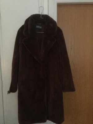 ESPRIT brun fuskpäls  - Underbart mjuk fuskpäls från ESPRIT i strl M. Väldigt rymlig men köpt för stor. Använd en gång så som NY. För sent att byta den tyvärr. 