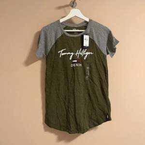 Tommy Hilfiger T-shirt i färgen khaki och grå. Helt ny och oanvänd med prislappen kvar på. Nypris 364 kr ungefär! 