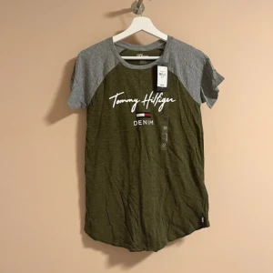 Tommy Hilfiger  - Tommy Hilfiger T-shirt i färgen khaki och grå. Helt ny och oanvänd med prislappen kvar på. Nypris 364 kr ungefär! 