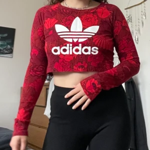 Adidas crop top - Röd blommig långärmad croptop från Adidas, sparsamt använd.