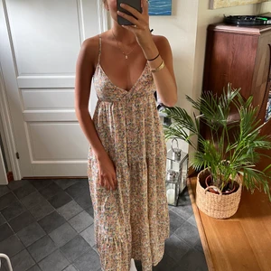 Lång klänning  - Blommig lång klänning i massa gosiga färger. Använt kanske 3 ggr och köptes för 699kr💛  Insydd för att få lite finare figur 🫶🏽