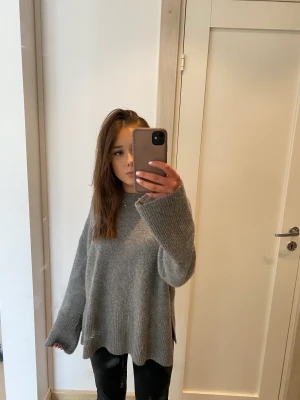 Stickad tröja - Stickad tröja från bershka med en slits på sidan, jätte bra skick använd ca 2 ggr. Jag är 158cm ifall du vill jämföra. Stor i passformen och passar nästan alla beroende på.