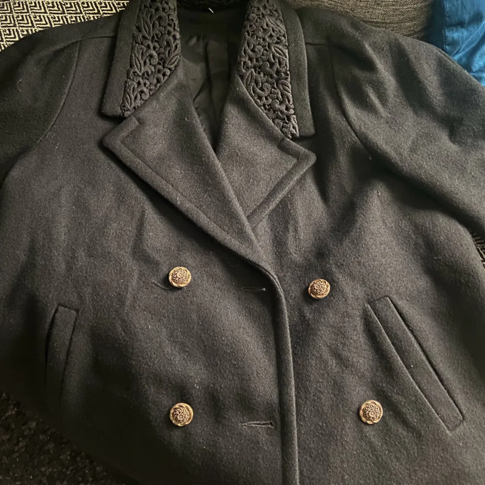 Barely worn, high quality, black thick coat with vintage gold buttons and detailing on the collar and cuffs. . Jackor.