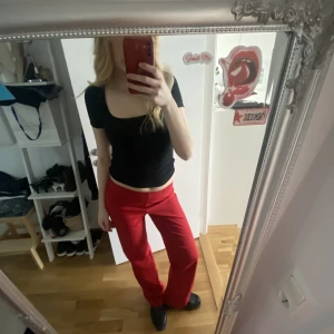 Röda lågmidjade kostymbyxor  - GALET snygga röda, långa (!!) och lågmidjade kostymbyxor. Köpta second hand för några år sedan men kommer för lite till användning… Är 173 cm lång och dessa lägger sig snyggt över skor på mig. Står ingen storlek men jag har 36/38 i byxor. 