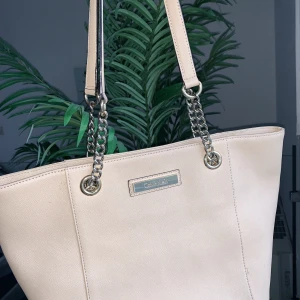 Calvin Klein väska - Knappt använd Calvin Klein väska i en fin nude rosa färg perfekt till våren/Sommarn. Stor och rymlig med bra fack för organisering. Köpt för 228 dollar. Säljs nu för 1300kr.