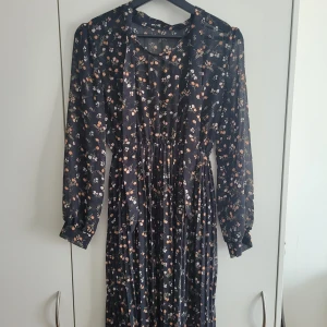 Blommig klänning  - Blommig klänning från Sydkorea. Överdelen är lite genomskinlig. Har även ett snöre som man knyter vid halsen