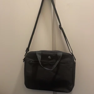 Dataväska - Grå dataväska, så praktisk och i superfint skick, enda defekten är att kedjan på nedre facket saknas men inget som syns alls. Perfekt för skolan att bära sin laptop i💓💞💖