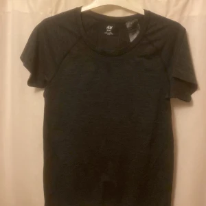 Tränings t-shirt  - Mörkgrå träningstopp från Hm, knappt använd. 