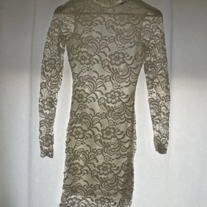 Spettsklänning, Studentklänning  - Fin spettsklänning, öppen rygg och långa armar, ej genomskinlig utan bilden tagen i motljus, perfekt till skolavslutningen eller student