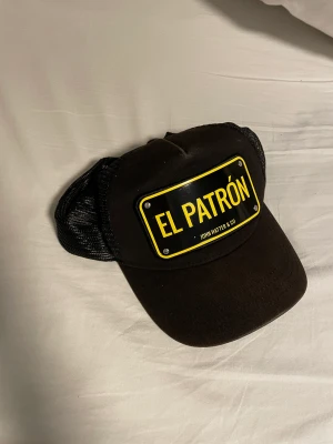 John hatter keps - Säljer en el patron  keps den är rätt använd men i bra skick. Man får med el patron lådan som den kom i.