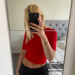 Supersnygg röd topp - Toppen kan dras ner och täcka mer av magen om man vill! Sitter tight. 