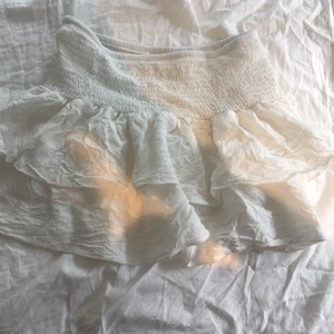 Vit volang kjol från Shein - Vit volankjol från Shein.Säljer den pågrund av fel storlek.andvänd en eller två gånger.köparen betalar för frakten.36cm i längd och 64cm i midjastorlek.