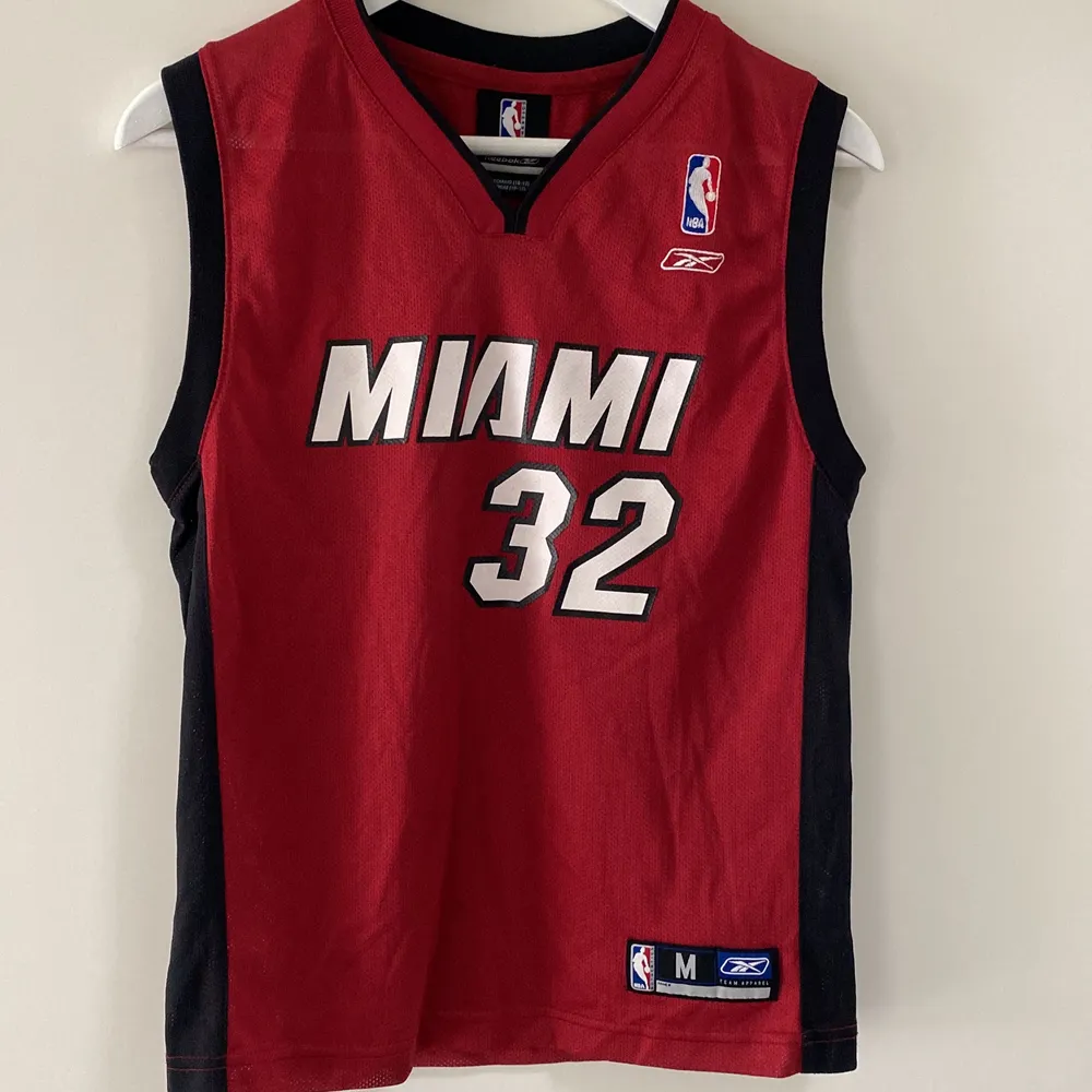 Miami Heat linne med Shaquille O’Neal #32. Inköpt i Florida när han var aktiv i den officiella Miami Shopen.  Givetvis helt äkta.  Använd av mig som liten.  Strl M barn, 10-12 år. . T-shirts.