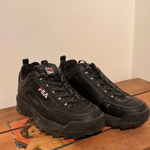 Fila skor i storlek 42 - Ett par nästan oanvända helsvarta Fila sneakers med reflex