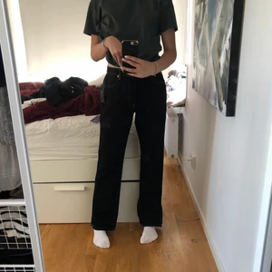 Jeans - Svarta jeans med vita sömmar. Slits längst ner vid benen. Nya med lappen på. Säljer för att dom inte passade när jag fick hem dom. Köparen står för frakten- 50 kr