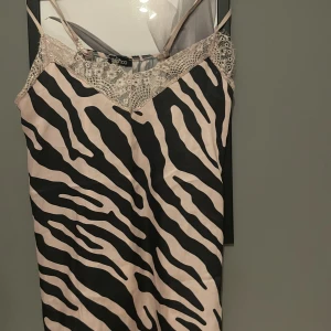 Boohoo linne i zebra mönster  - Ett mönstrat linne i satin. Använts ett par gånger inga missfärgningar/övriga skador. Passform i storlek XS/S. 