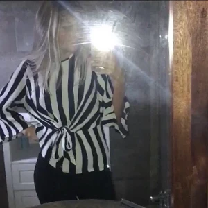  Festtopp med vida ärmar och knytdetalj - Snygg randig blus med vida ärmar och knytdetalj framtill. Använd ett 1-2 gånger. Köpare står för frakten😊