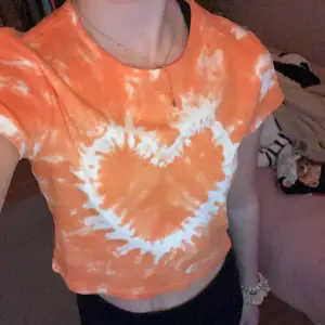Orange färjad t-shirt med ett slags hjärta på. Kommer aldrig till användning. Storlek S men passar även XS. Köparen betalar frakt