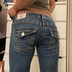 True Religion jeans  - Ett par true religion bootcut jeans som är klippta längst ner. Dom är boocut. Köpare står för frakten annars kan jag mötas upp i Sthlm. Rensar min garderob så har inte plats. Midjemått: 38 cm, 82 cm  Innebenslängden: 73 cm 