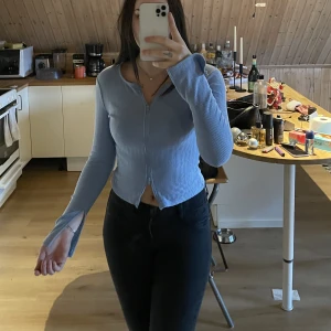 Topp - Blå topp med dragkedja både uppe och nere även slits på armarna, knappt använt